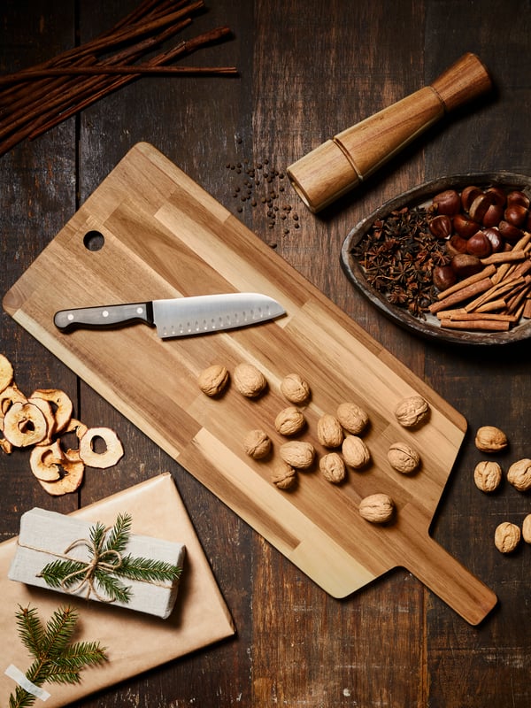 Large wood SMÅÄTA cutting board with a knife and walnuts on top.