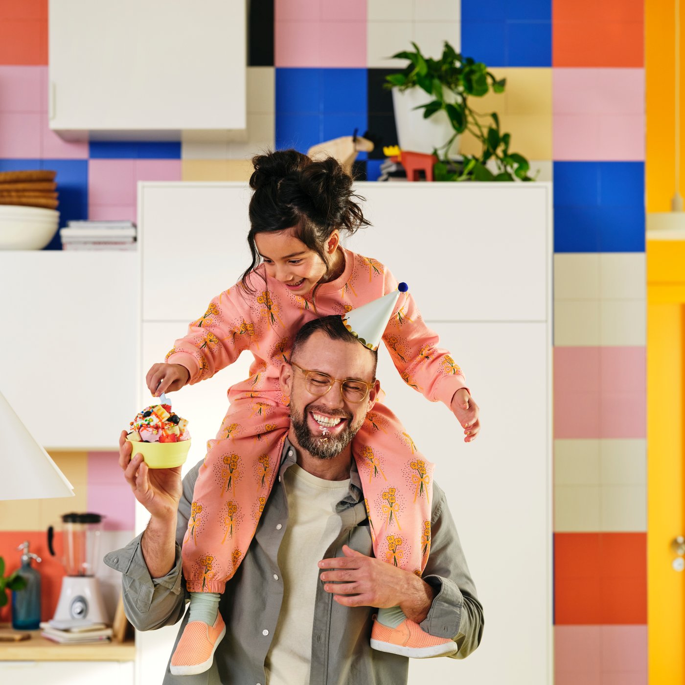 Adult carrying a smiling child on their shoulders during a Father's Day celebration.