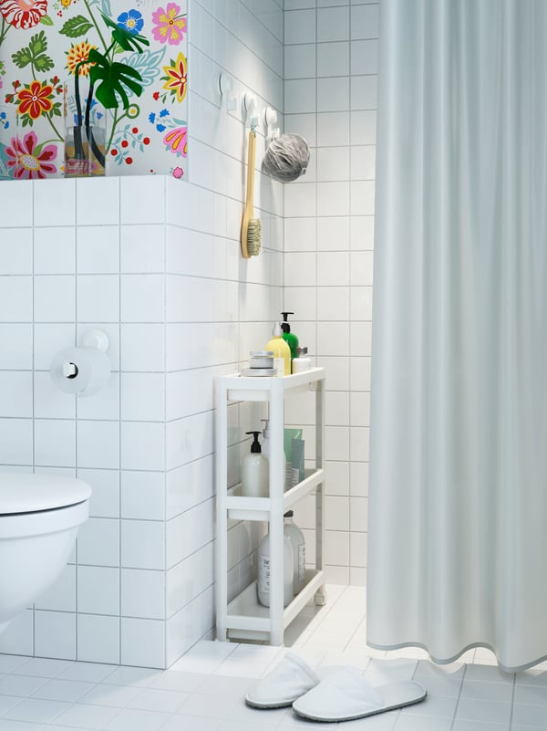 Baño de color blanco con una cortina de la serie VÄNNEÅN en el mismo color.