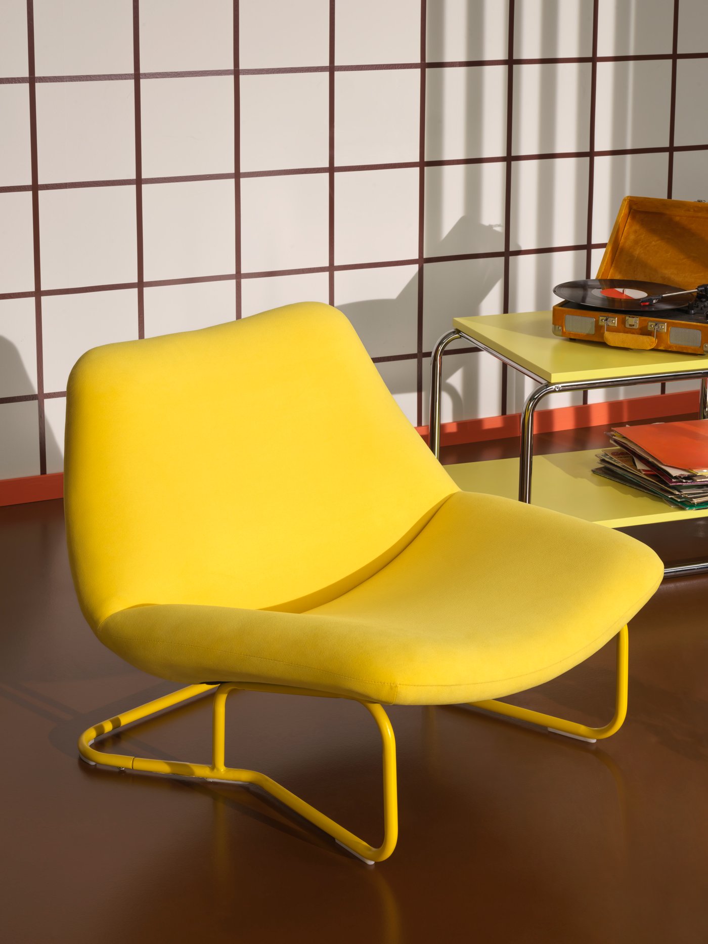 A yellow SOTENÄS armchair next to a BAGGBODA coffee table.