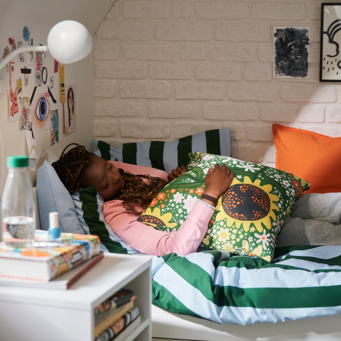 A bright orange GURLI cushion cover in the bedroom