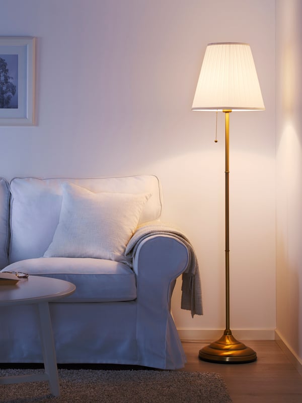 A brass/white ÅRSTID floor lamp