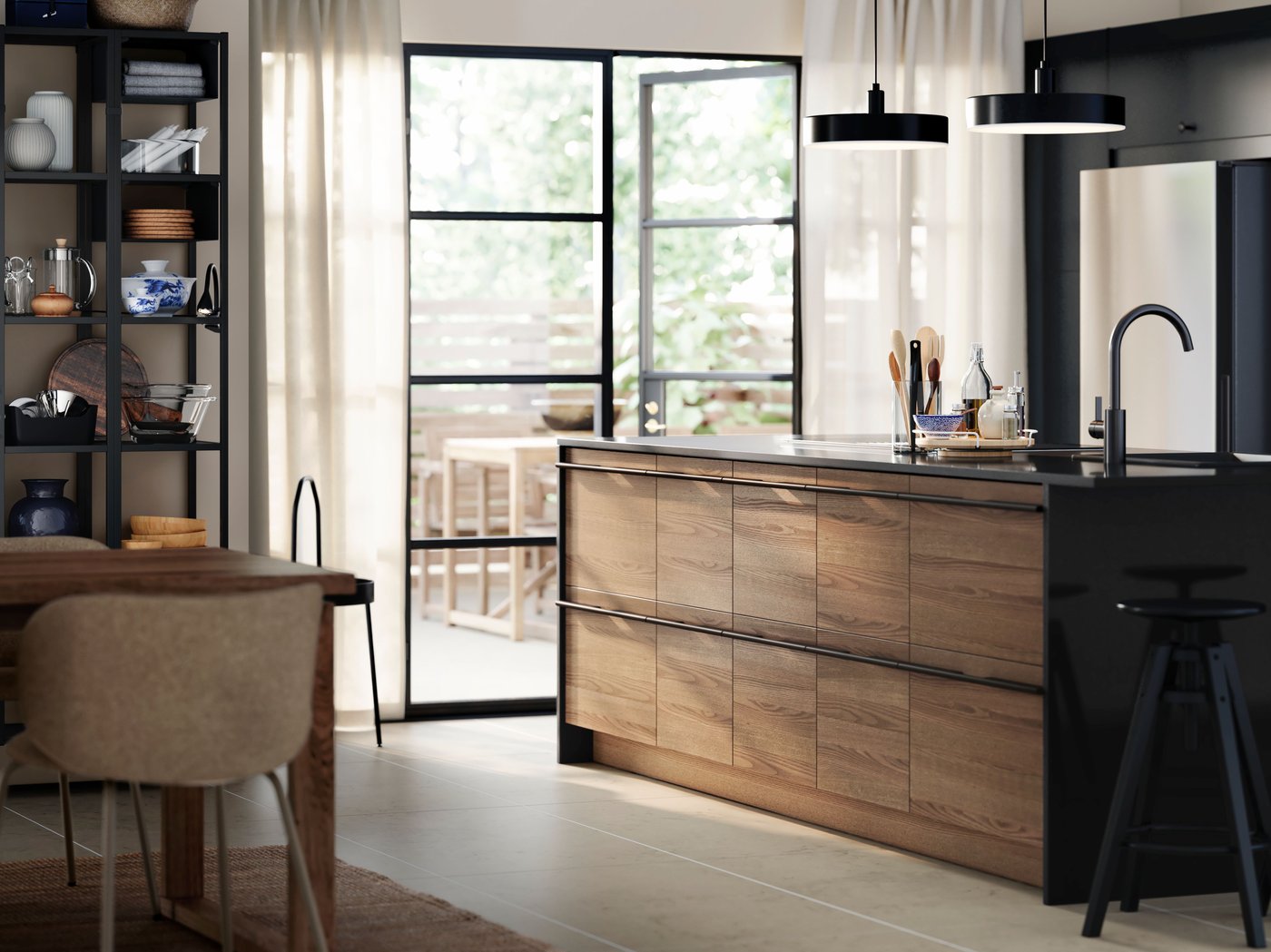 A bright kitchen with a STENSTA dark brown ash veneer drawer fronts, black bar stools, open shelving, and a dining table.