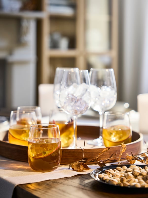 Una bandeja con copas de cristal y vasos STORSINT.