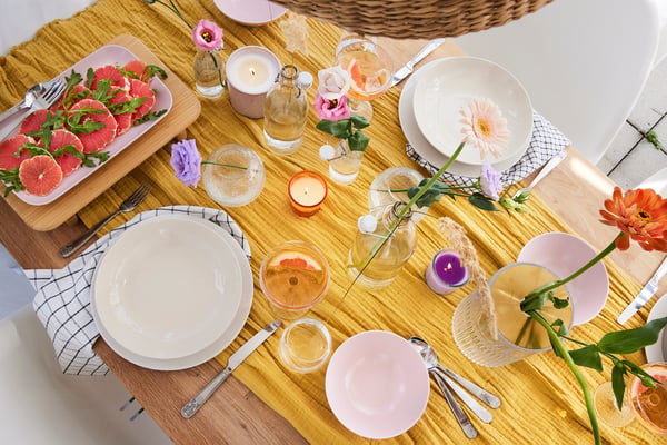 A table setting with plates, various glasses and a checked cloth napkin