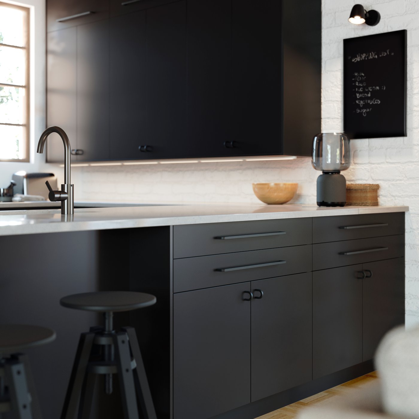 Una cocina con muebles de cocina METOD negros y cubierta blanca.