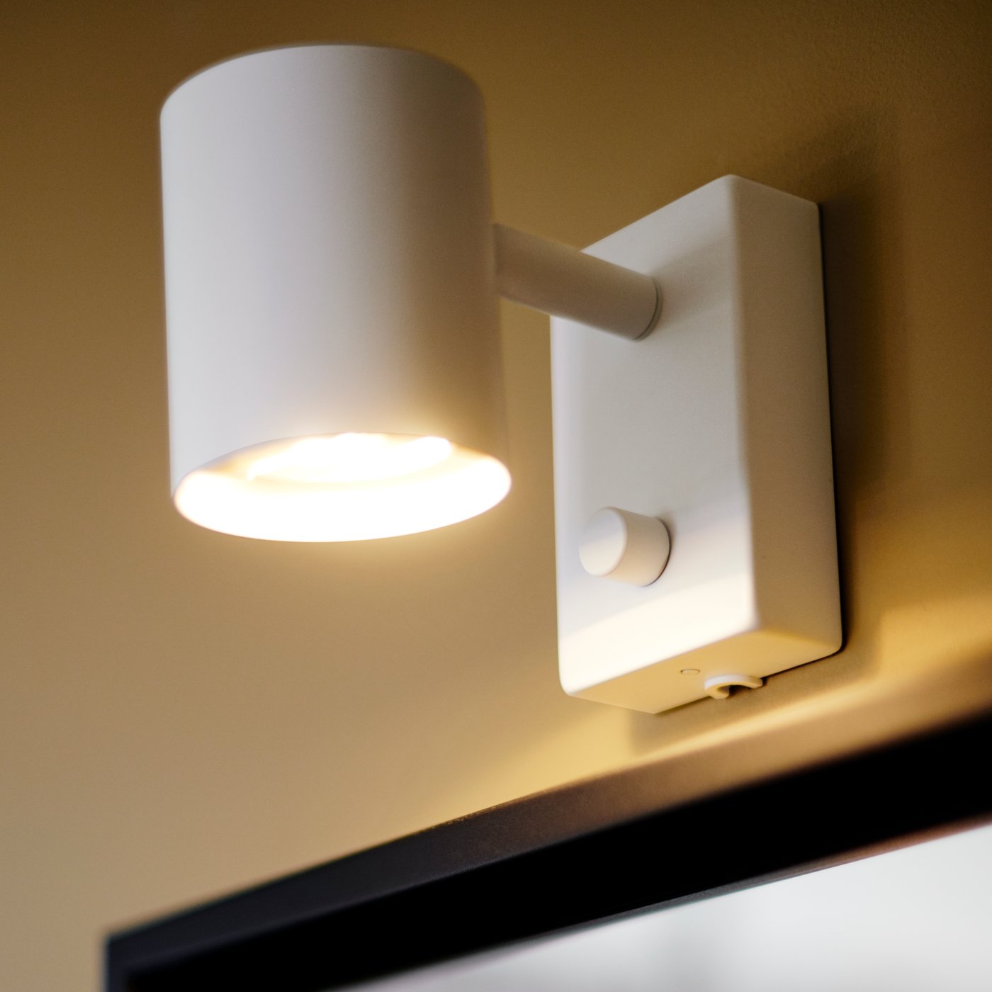 A white NYMÅNE wall/reading lamp in the living room