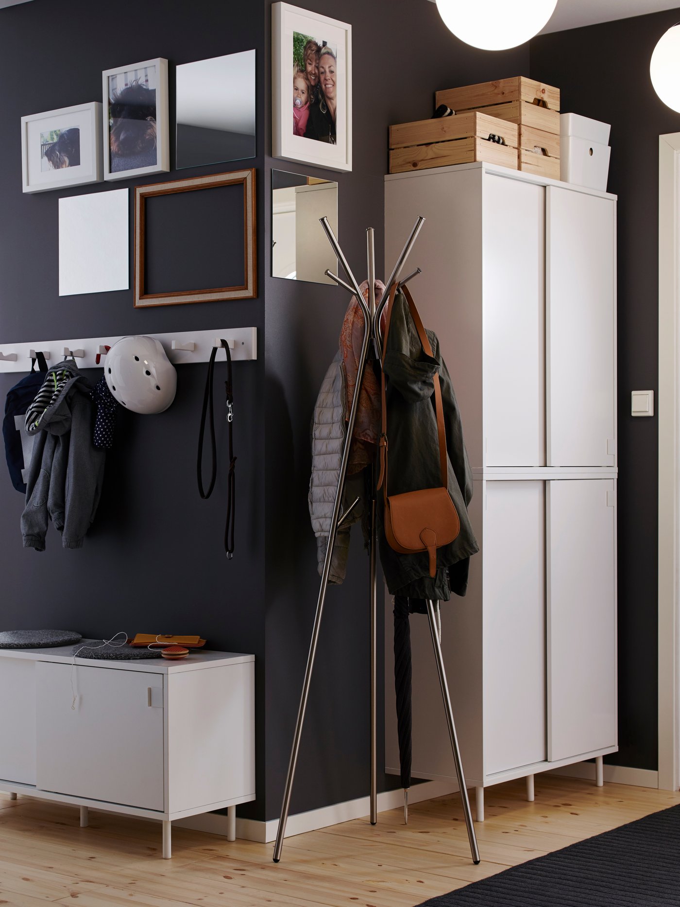 Coat rack is in a hallway with black walls.