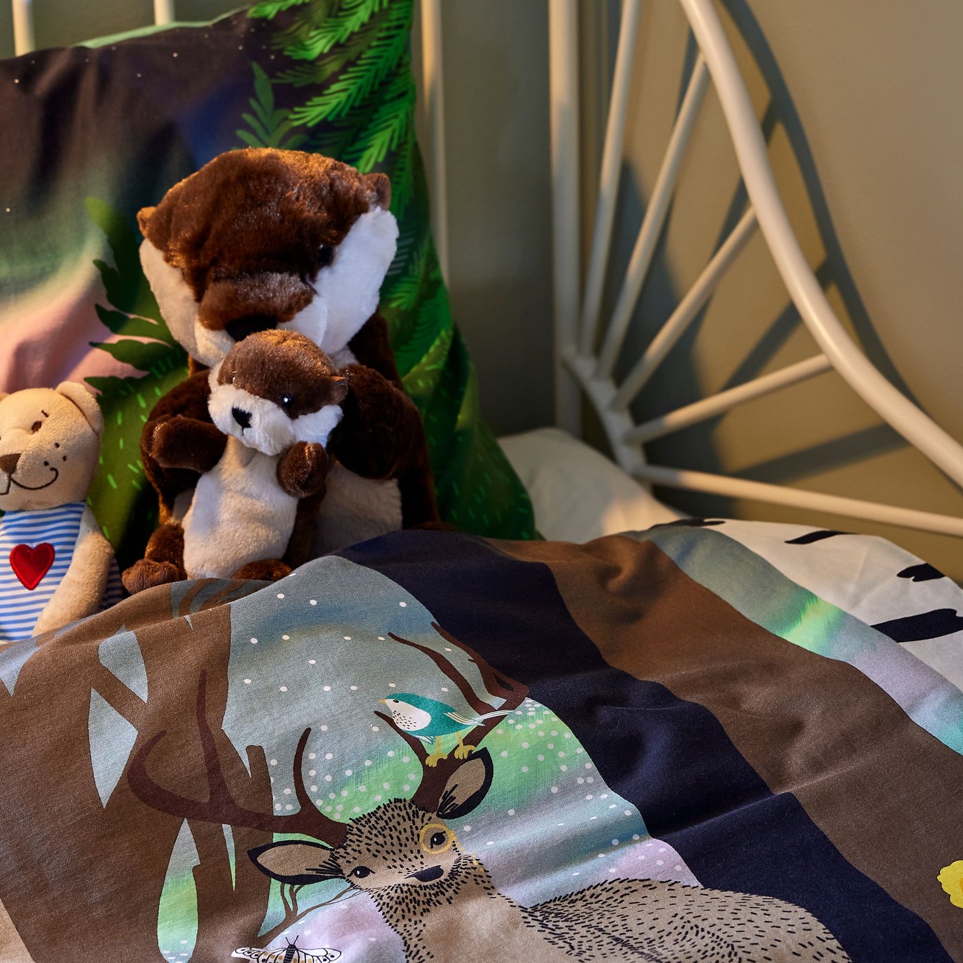 A children’s room with BUSUNGE extendable bed, SKOGSDUVA bedding and big soft toys in the bed.