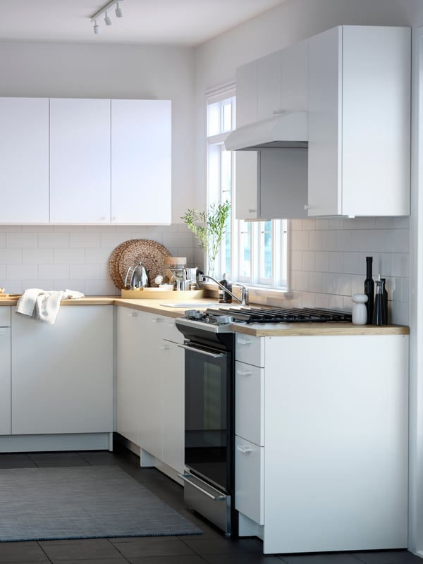 Un mueble bajo KNOXHULT blanco con cajones para la cocina.