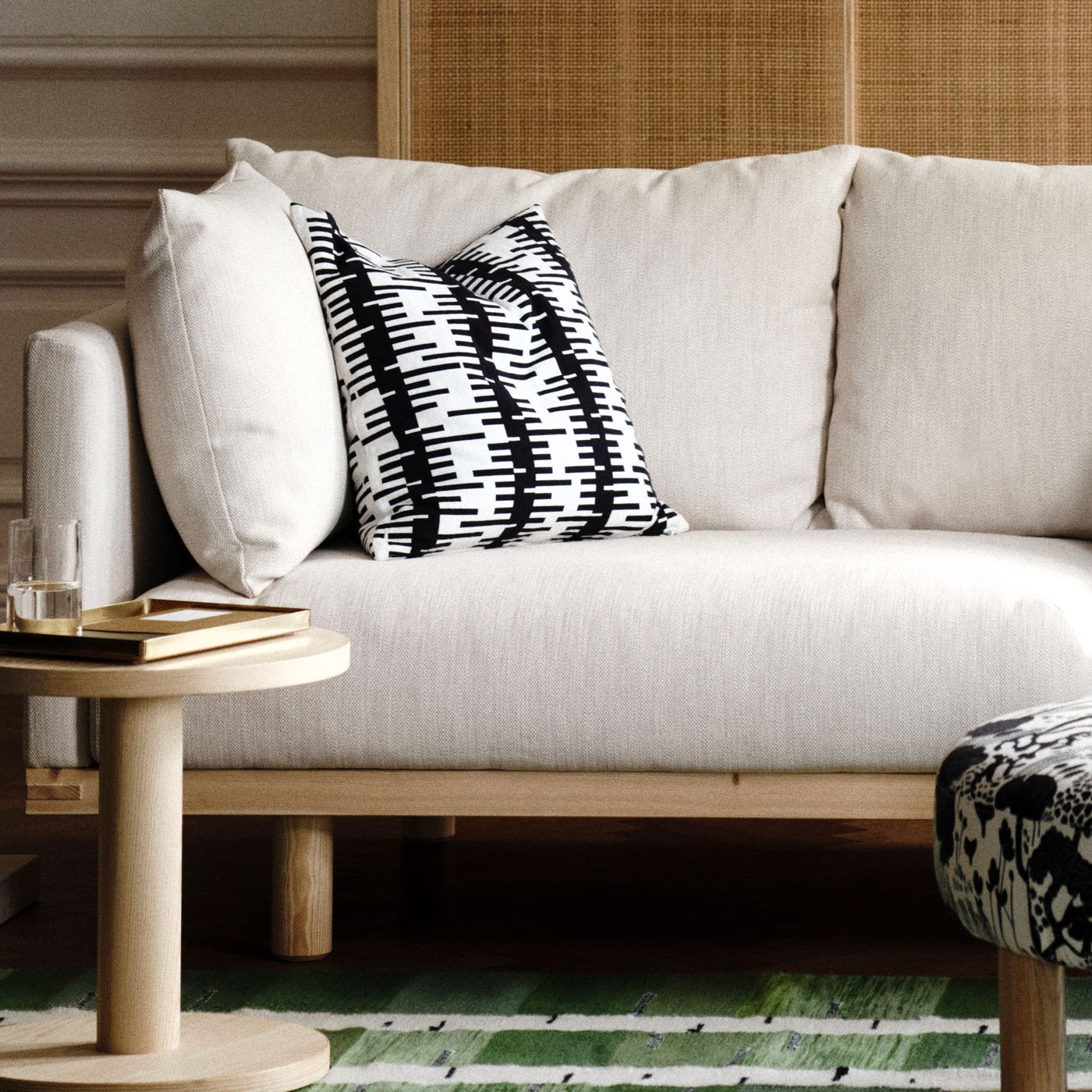 En närbild på en beige soffa med underrede i trä.