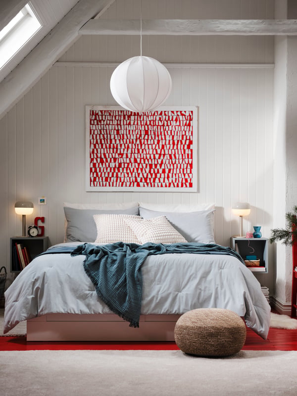 Ein Schlafzimmer mit Dachschräge, einem Bett aus unserer Brimnes Serie, verschiedenen Decken und Plaids und mehr für eine gemütliche Stimmung.