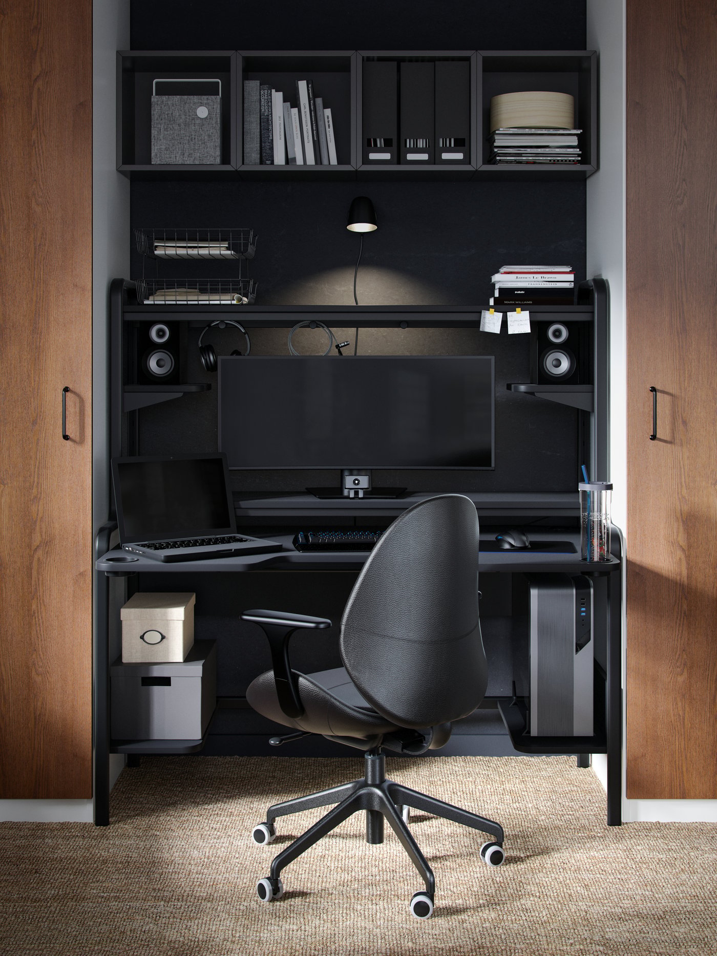 A black IKEA FREDDE gaming desk with a matching black desk chair.