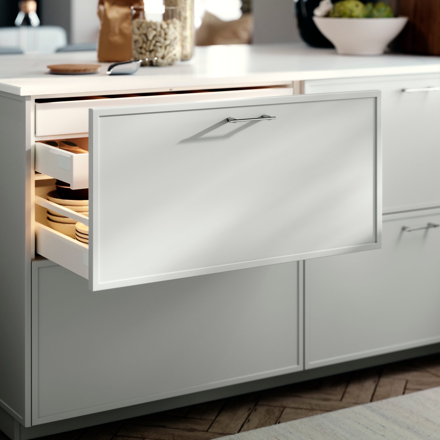 A METOD kitchen drawer with an ASPUDDEN drawer front in light grey, opened slightly revealing bowls inside.
