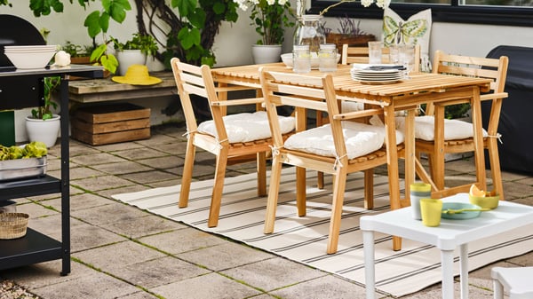 Ensemble table et chaises d’extérieur sur un tapis dans un espace terrasse