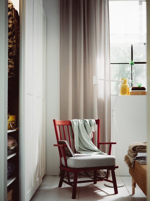 A brown-red/Tibbleby beige/grey PERSBOL armchair and NYMÅNE floor/reading lamp below a window with a beige DYTÅG curtain.