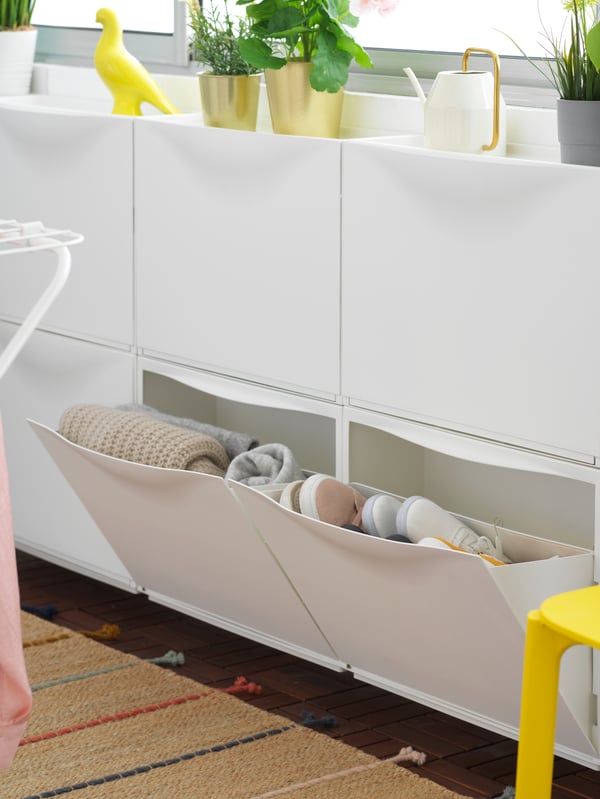 A white TRONES shoe cabinet/storage in the laundry room