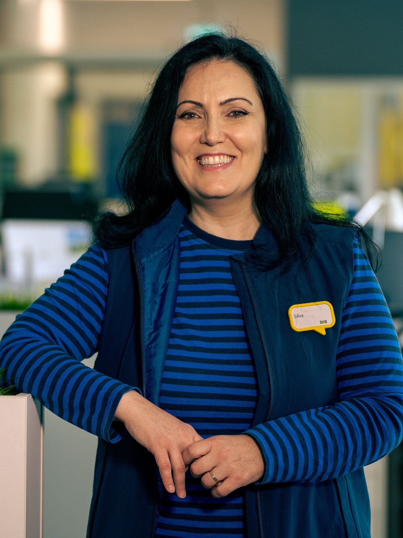 Silva u plavoj radnoj uniformi stoji u pozadinskoj kancelariji.