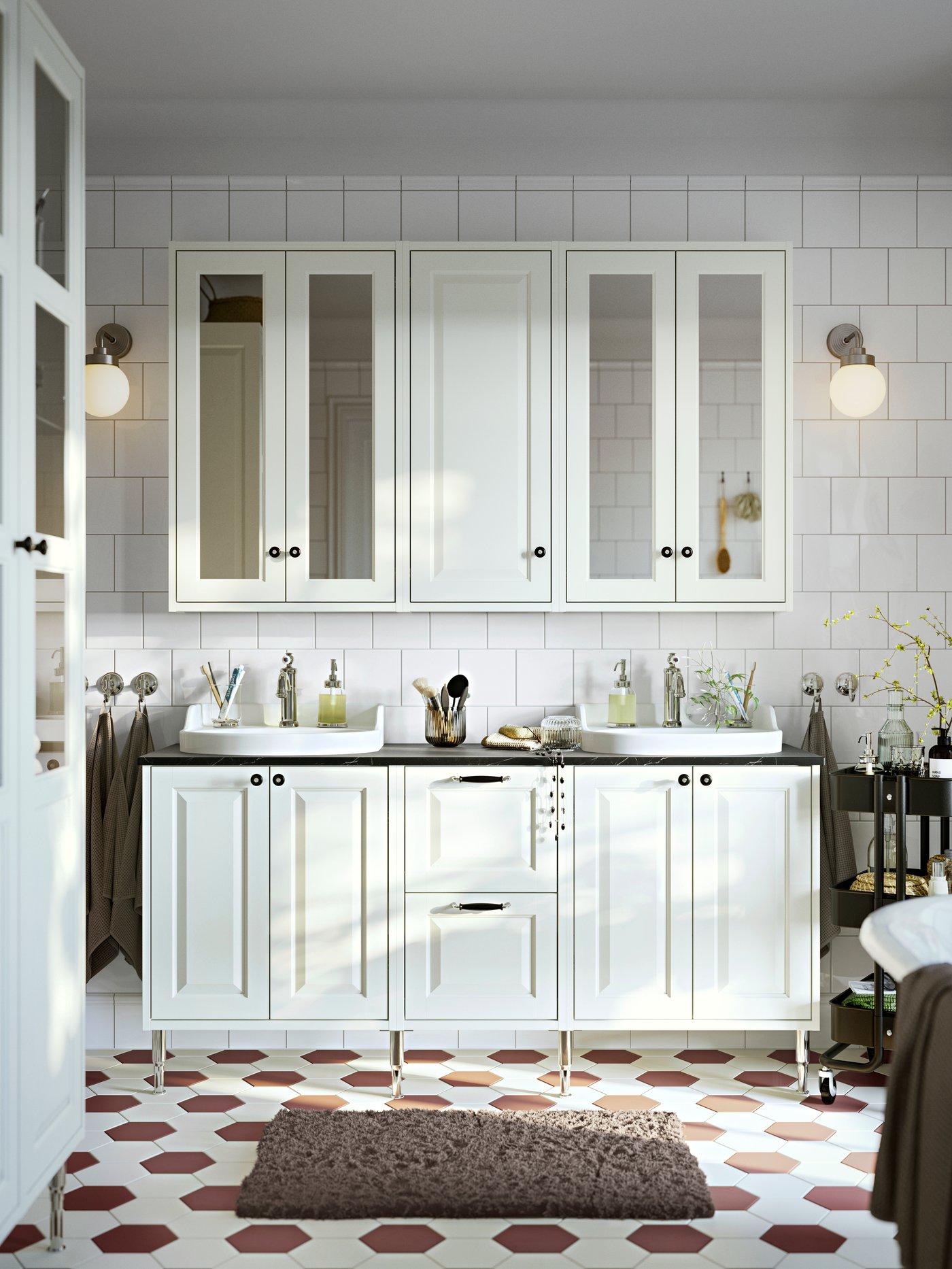 A frontal view of a bathroom with white TÄNNFORSEN wash-stands with doors and drawers and mirror cabinets with doors.