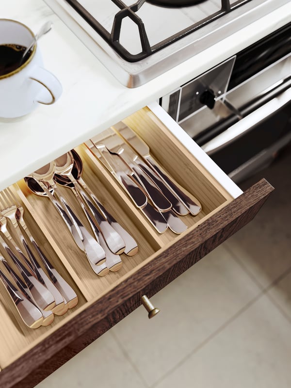 An open drawer with VARIERA organisers filled with black cutlery.