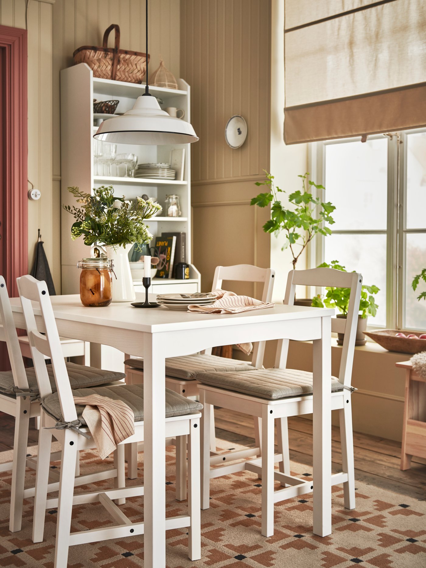 A white HAUGA table and four white HAUGA chairs stand in a dining area under a white TRETTIOEN pendant lamp.