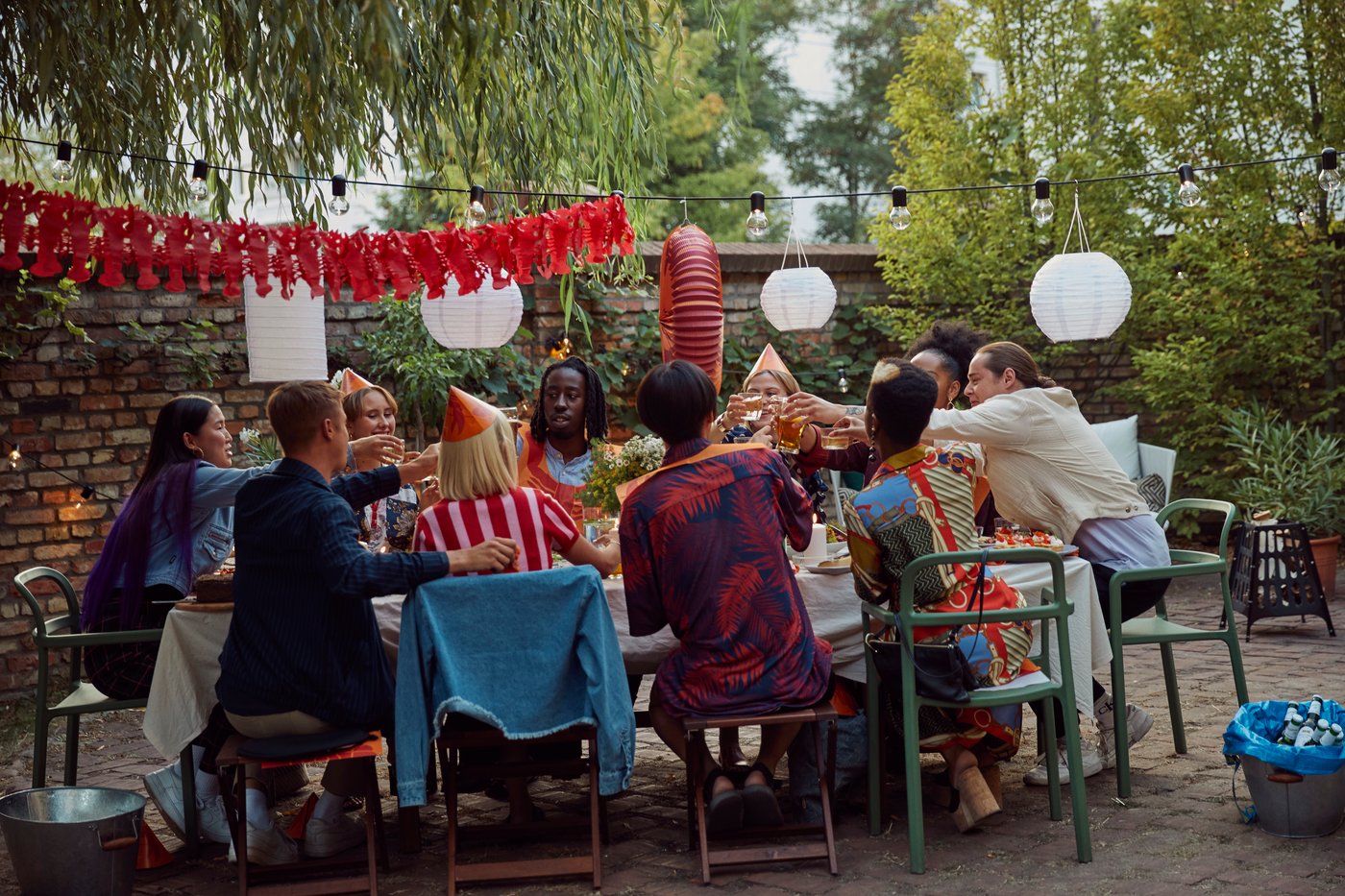 A group of friends sitting at a dining table in a backyard enjoying a crayfish feast.
