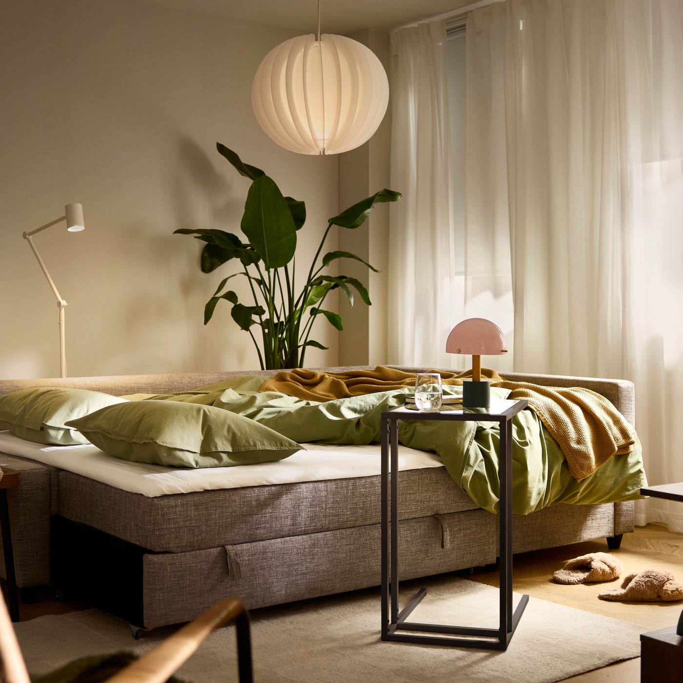 A FRIHETEN/KLAGSHAMN corner sofa-bed, shown as a bed, stands in a softly lit living room with a VOLLERSLEV rug.