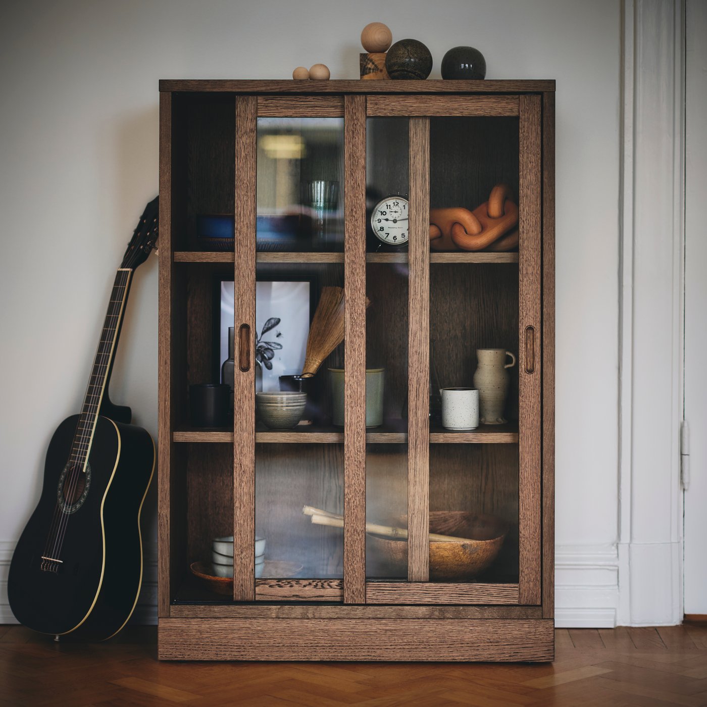 A brown stained oak veneer TONSTAD cabinet with sliding glass doors
