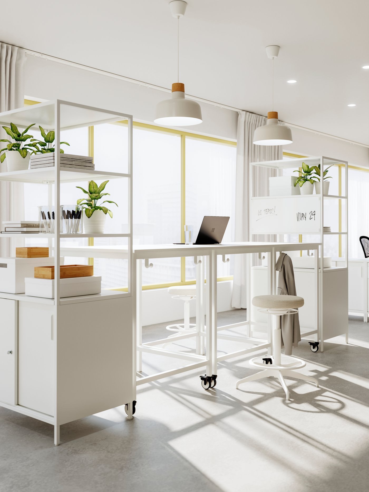 A workspace formed by a combination of white TROTTEN frames and cabinets beneath beige-and-birch BUNKEFLO pendants.