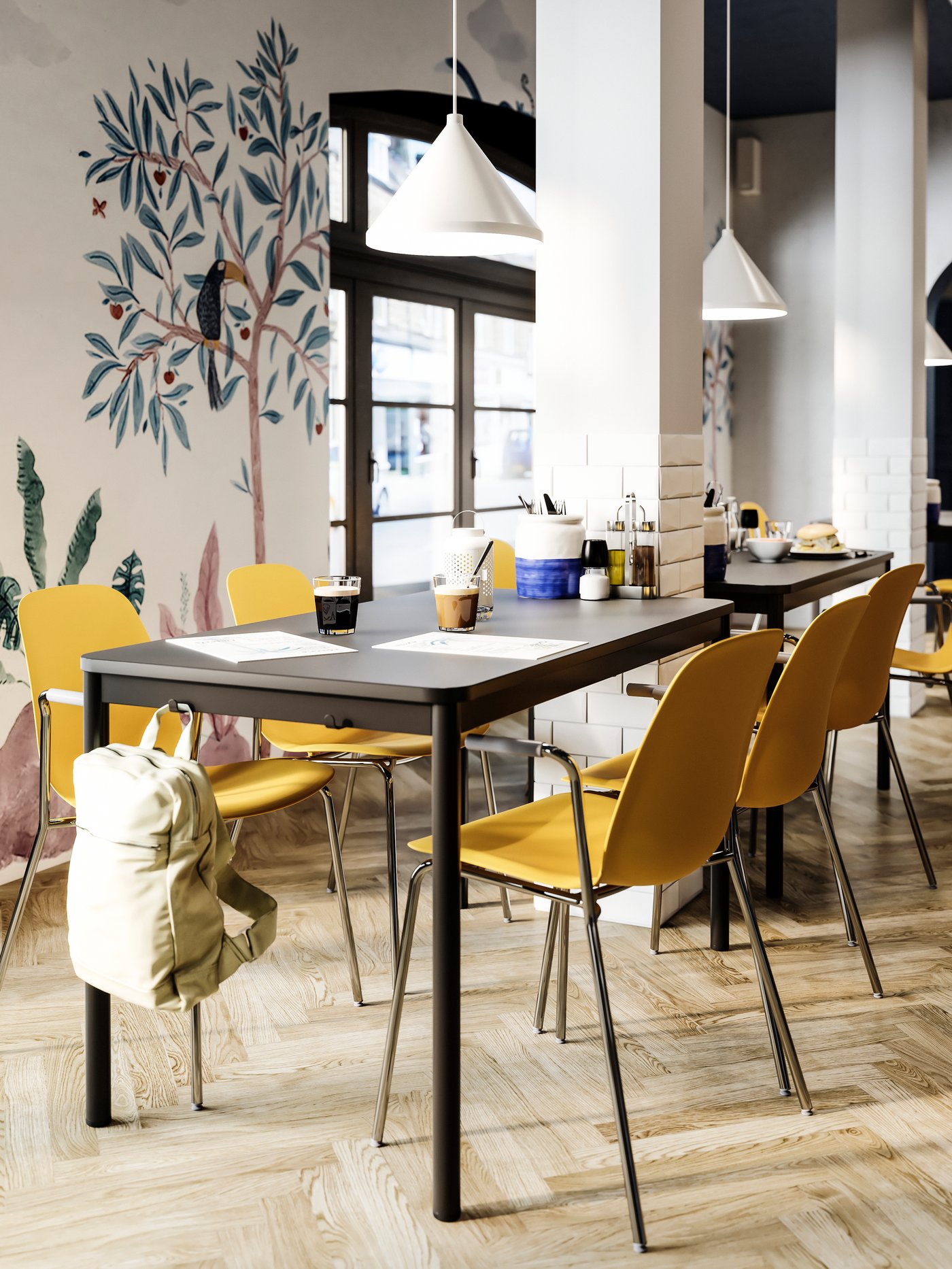 A dining table with hooks on the side where a beige bag hangs, dark yellow chairs, white pendant lamps, a painted wall.