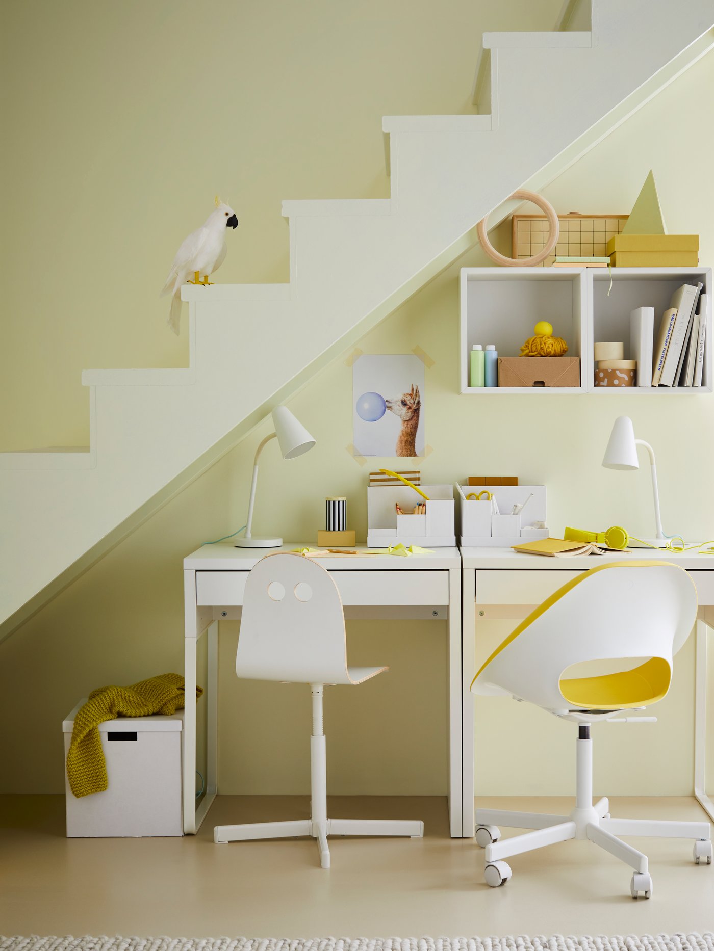 A MICKE desk with a desk lamp under the stairs in the living room, with an office chair.