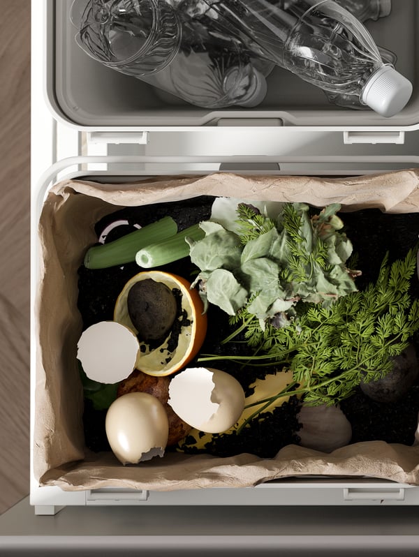 Two HÅLLBAR bins in a kitchen drawer recycling station. One contains a paper bag of organic waste and the other PET bottles.