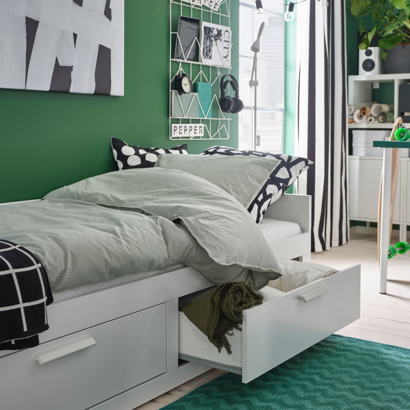 Ein grüner BREDEVAD-Teppich mit Zickzackmuster, flachgewebt, im Schlafzimmer