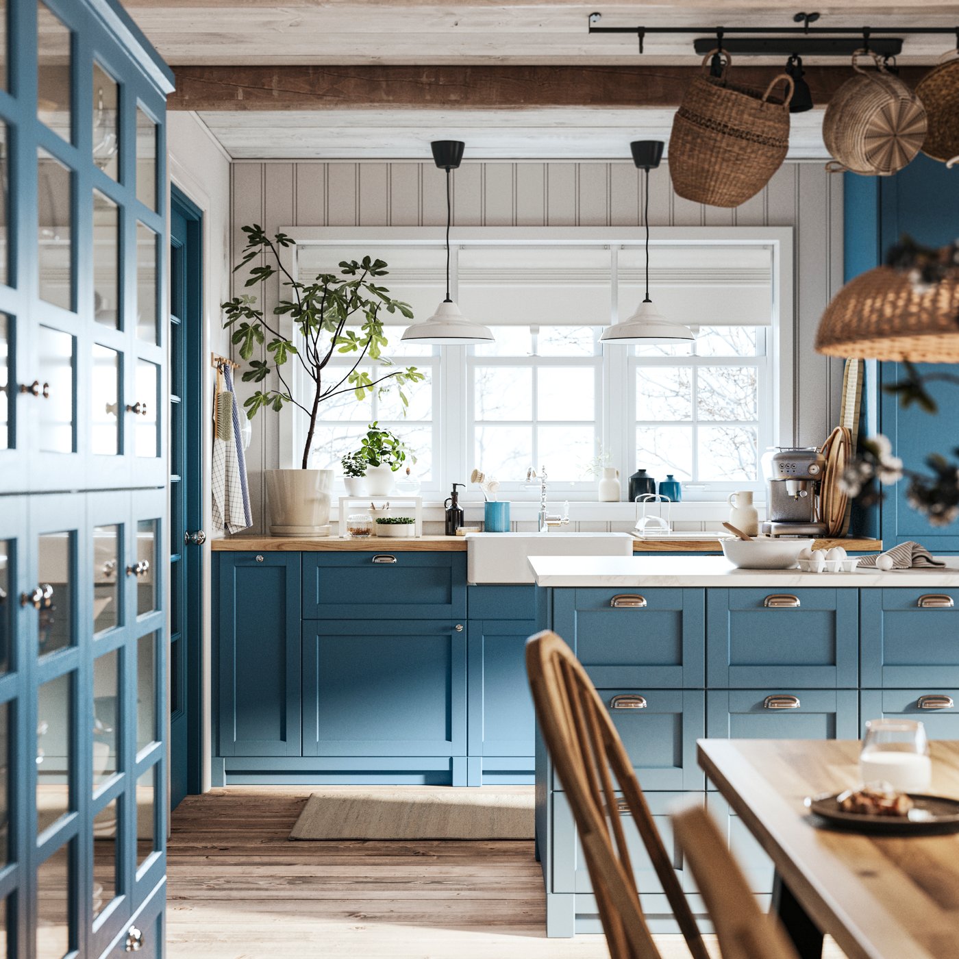 A traditional SEKTION kitchen with blue LERHYTTAN fronts has pots and pans hanging from a wall rail.