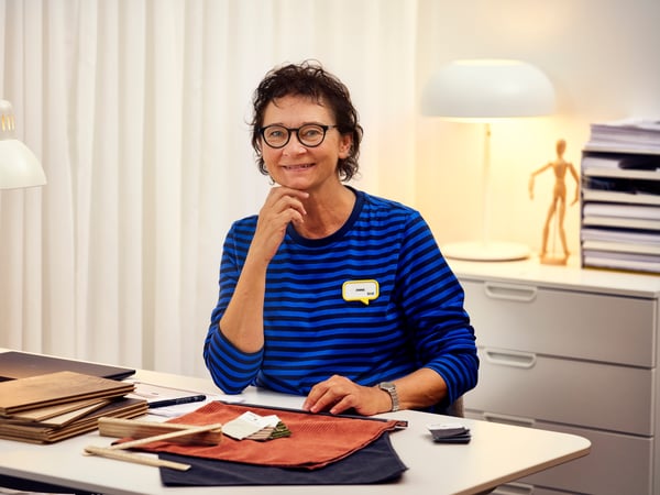 Notranja oblikovalka podjetja IKEA sedi za mizo, pred sabo pa ima več vzorcev materiala.
