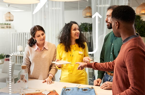 Un designer d'interni IKEA dà consigli a diversi clienti.