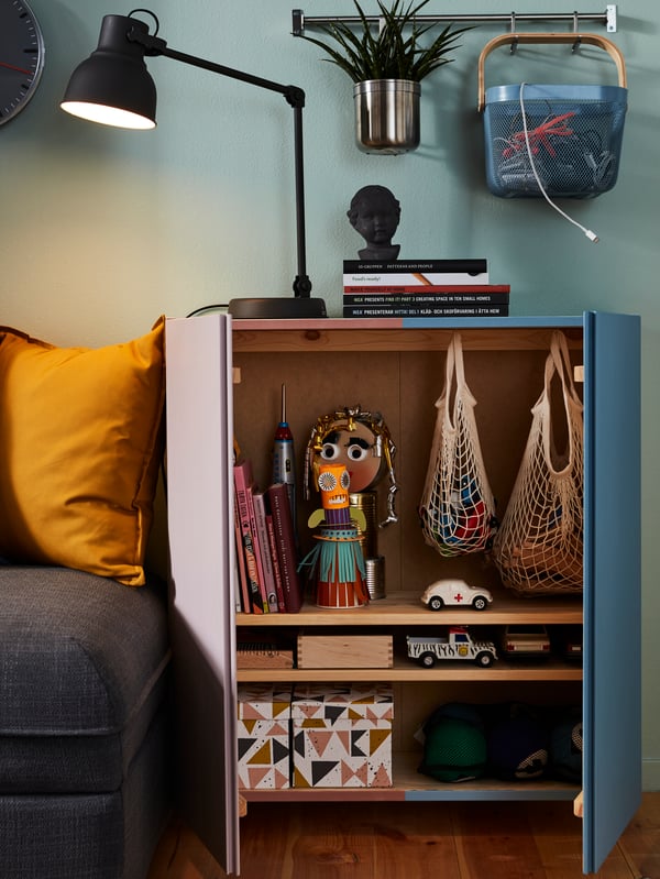 Ein offener Schrank im Wohnzimmer. In ihm sind zwei KUNGSFORS Einkaufsnetze, mehrere Boxen und Spielzeug zu sehen.