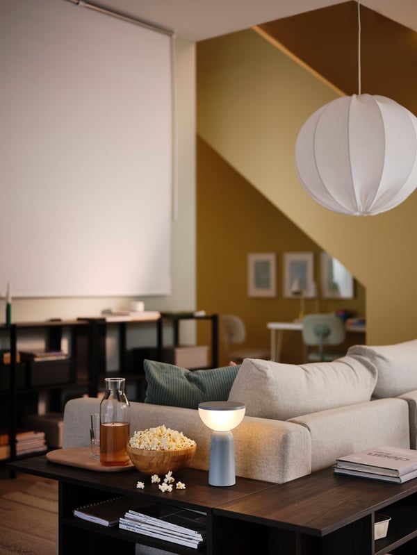 A yellow living room has a FRIDANS block-out roller blind on one wall, in front of a VIMLE 2-seat sofa and two side tables.