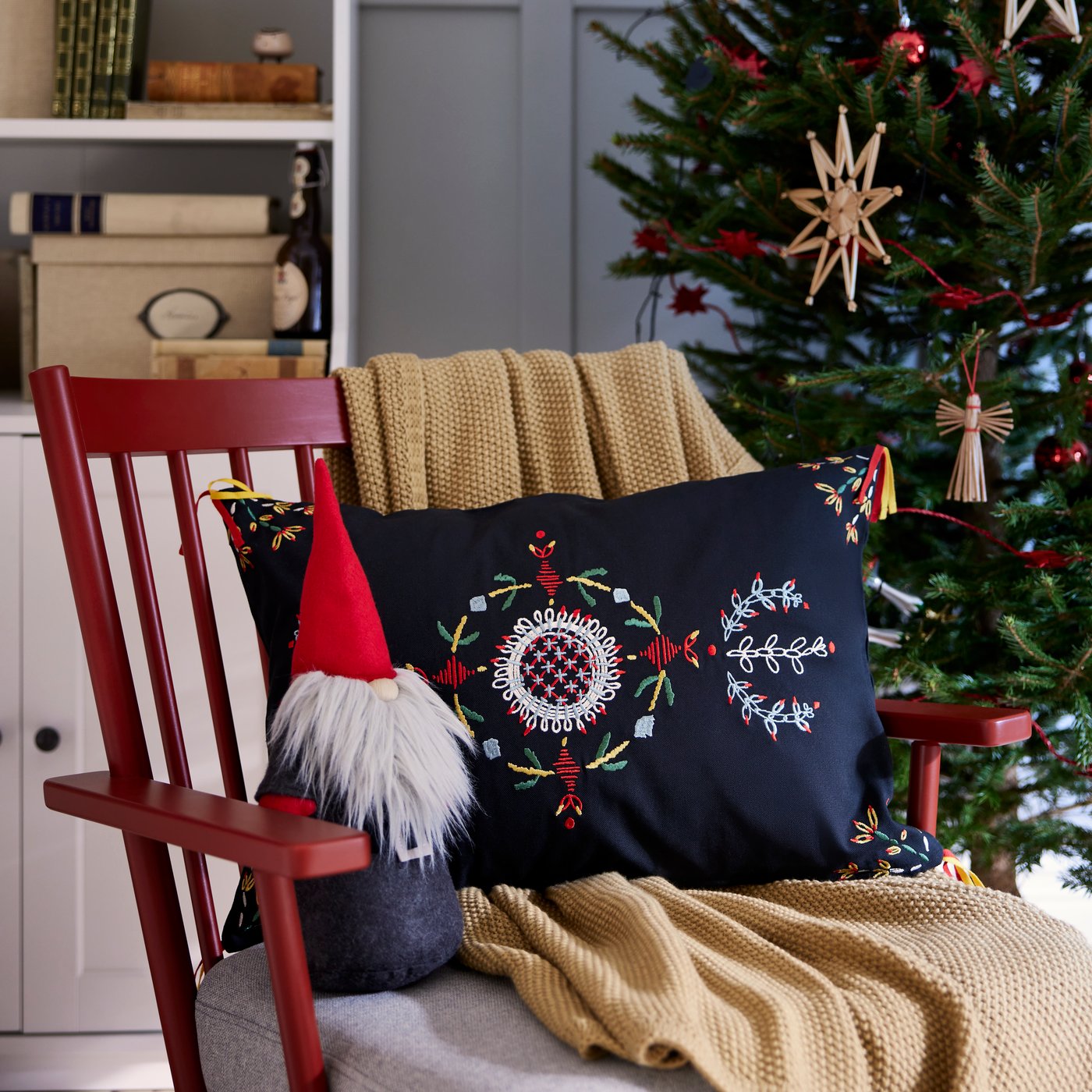 Le Père Noël est assis dans un fauteuil rouge.