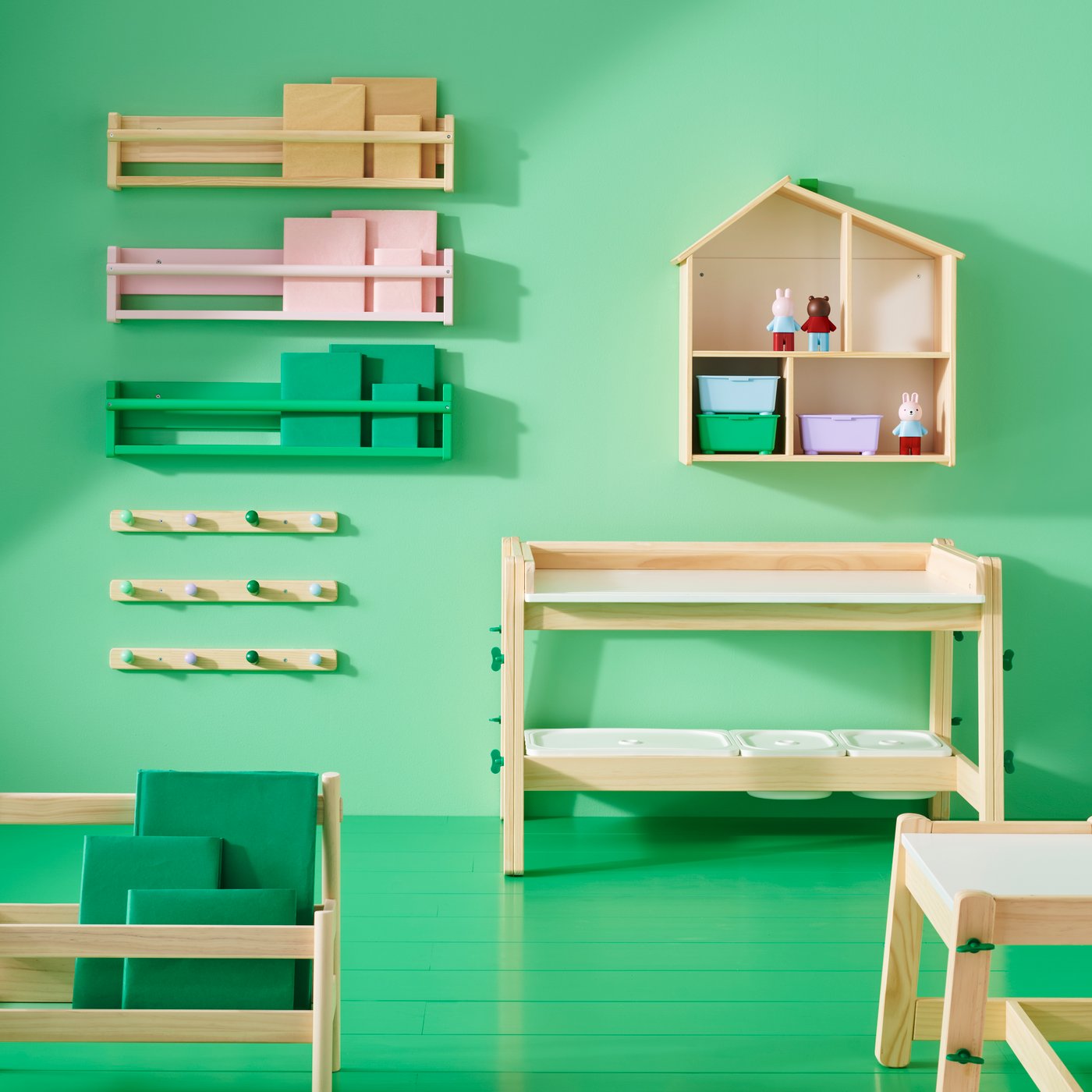 Various items from the FLISAT series including an adjustable desk and bench, wall storage and hook rack in a green room.