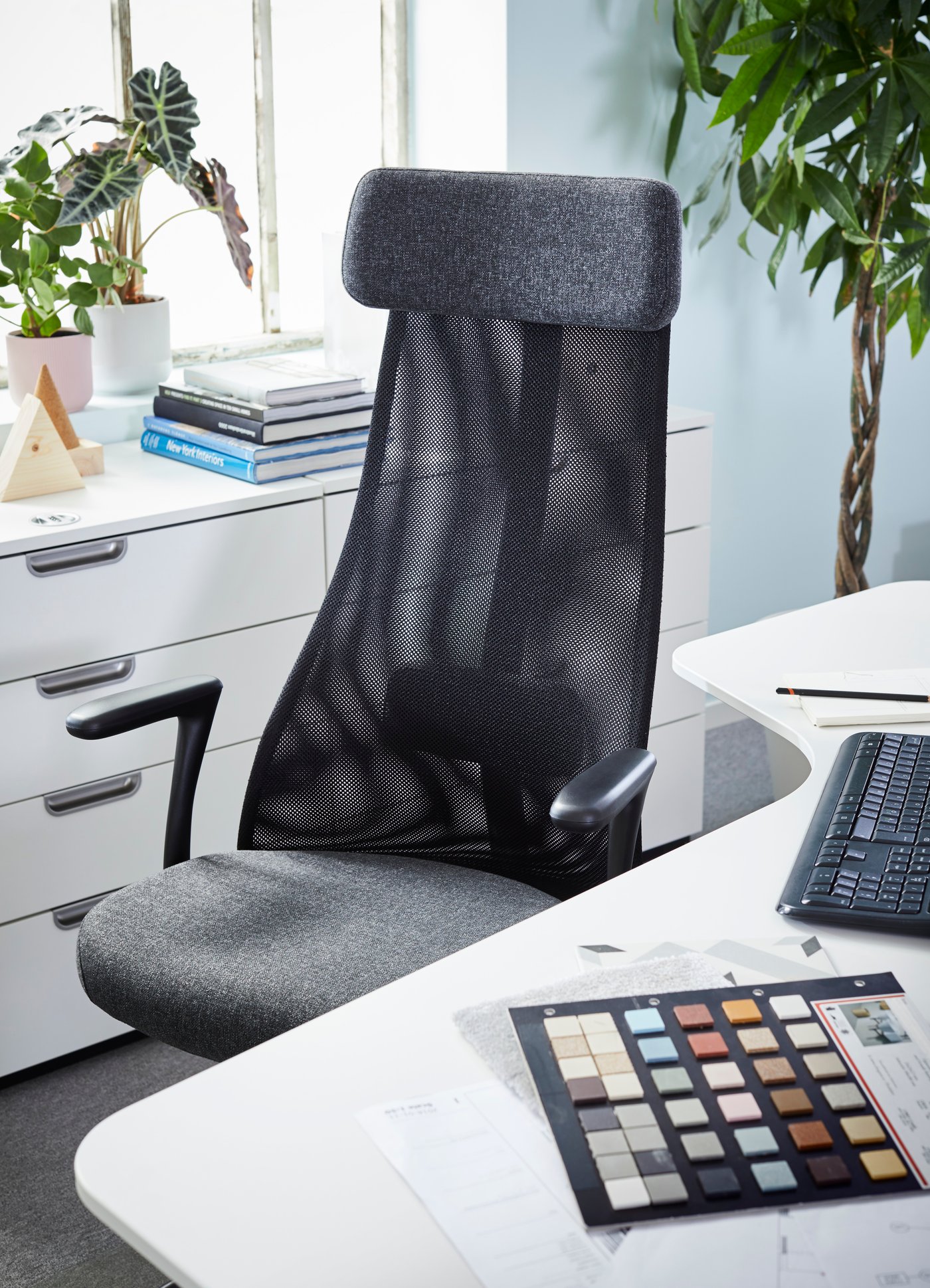 Mueble estante blanco de oficina GALANT junto a silla de oficina JÄRVFJÄLLET negra.
