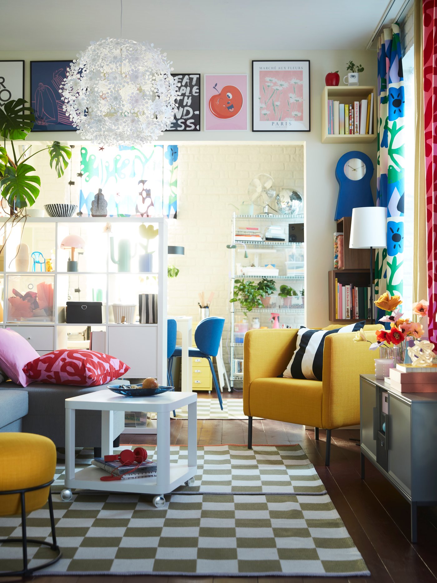 Ein lebendiges Wohnzimmer mit KLASSRUM-Teppichen, einem ÄLVDALEN-Schlafsofa, einem TINGBY-Beistelltisch, einem EKERÖ-Sessel und reichlich Dekoration.