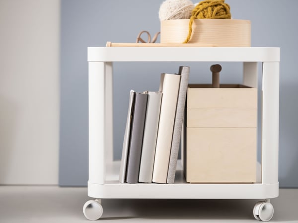 White table with storage boxes and books.