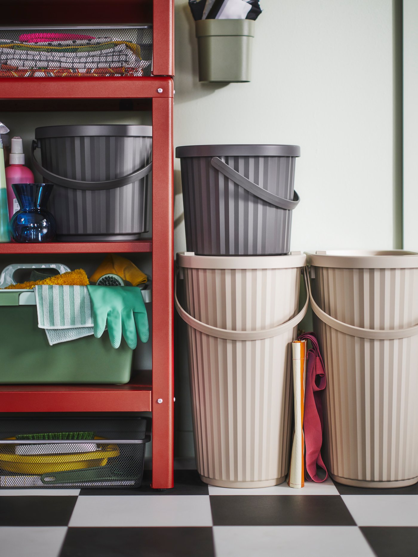 DAMMÄNG bins with lid of different sizes and colours stand on a black and white floor and on a shelf.