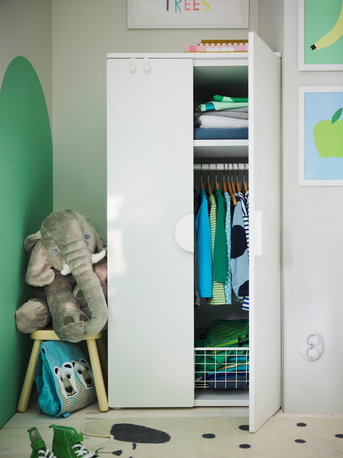SMÅSTAD wardrobe with one door open to show clothes in neat order. A soft toy elephant squeezed between wall and wardrobe.