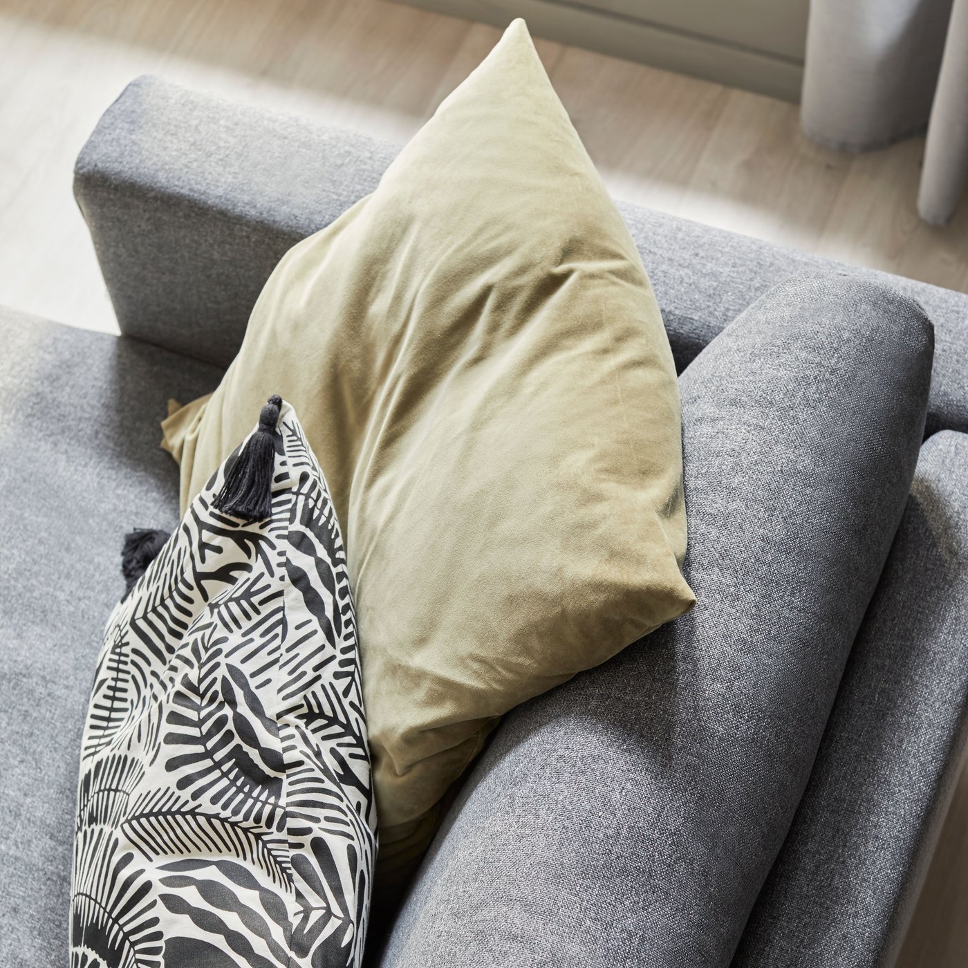 A light olive-green SANELA cushion cover