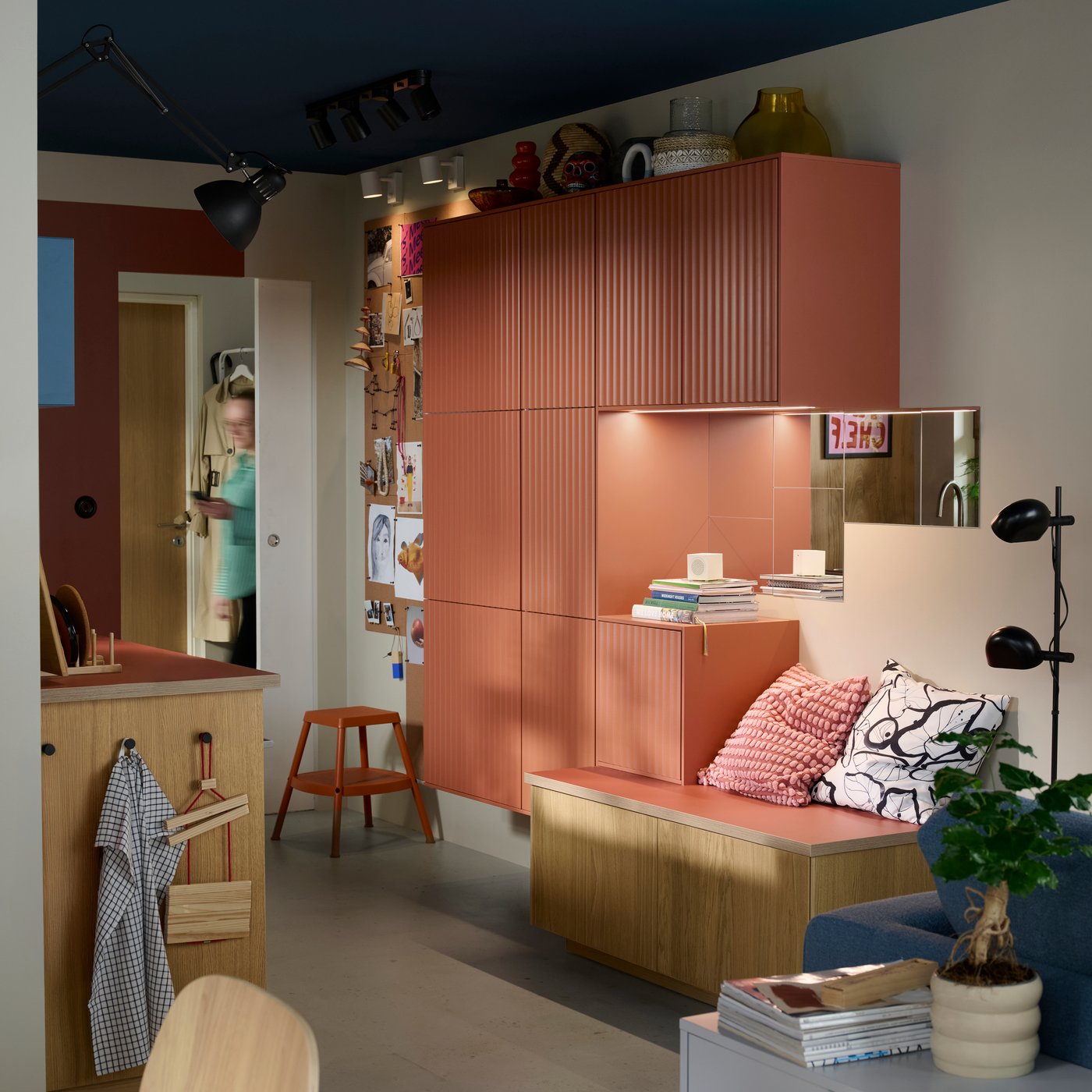 Several METOD kitchen cabinets with TERRSJÖ doors with a red-brown wave pattern are mounted on a wall in a small kitchen.