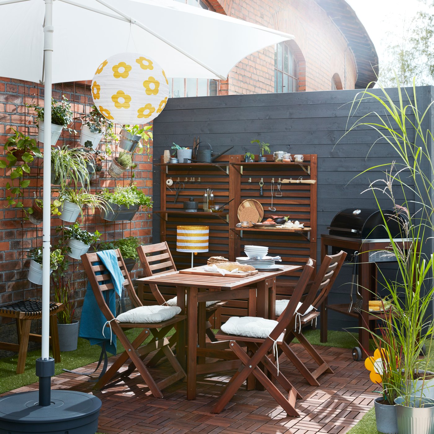 Un comedor de exterior con un juego de comedor ÄPPLARÖ y al costado un toldo.