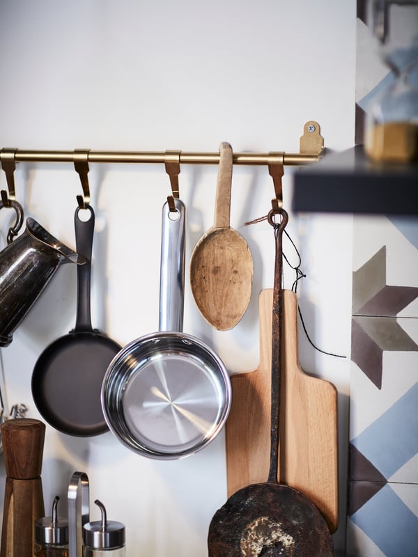 KNOPPÄNG posters and NEREBY birch rails on a white wall, with utensils on white hooks and in hanging NEREBY containers.