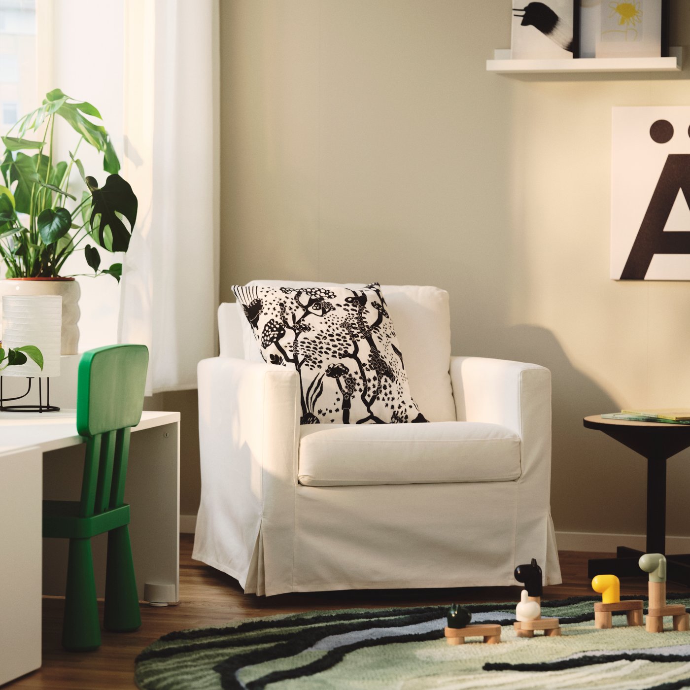 Living room with a SALTSJÖBADEN rocking chair and a decorative cushion.